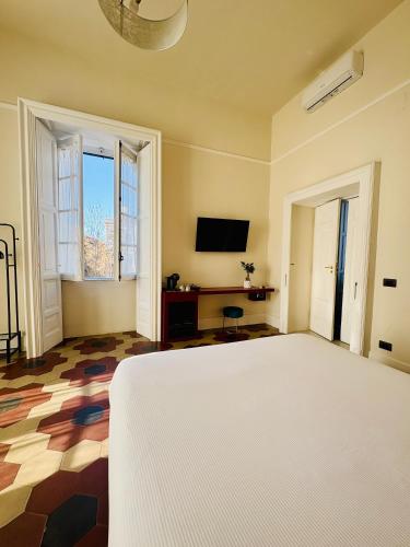 a bedroom with a large bed and a tv at Voglia 'e turnà in Naples