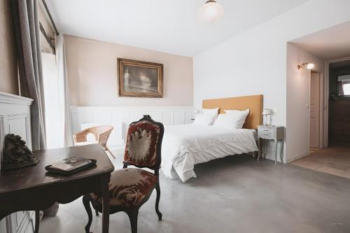 a bedroom with a bed and a desk and a chair at La Maison de Romain in Puycelci