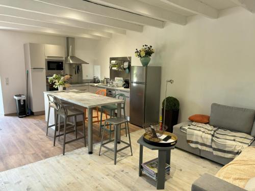 une cuisine et un salon avec une table et un canapé dans l'établissement gîte Armandine - séjour paisible au coeur du Tarn proche de Cordes-sur-Ciel, à Cahuzac-sur-Vère