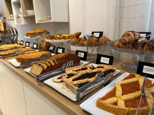 a buffet filled with different types of bread and pastries at Hotel Ravello Adults Only in Rimini