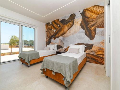 twee bedden in een kamer met een muurschildering bij Villa Donnosanto a 5 Minuti Da Spiaggia. Ostuni 10 in Carovigno