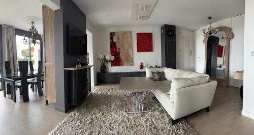 un salon avec un canapé blanc et une table dans l'établissement Rez de jardin avec vue mer à saint jean, à Saint-Jean-Cap-Ferrat