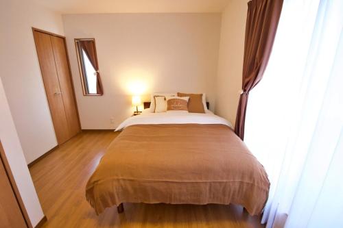 a bedroom with a bed and a large window at 今帰仁村兼次戸建て in Shushi