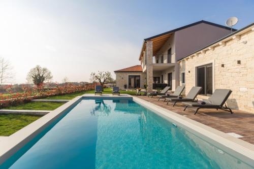 a swimming pool in the backyard of a house at Villa Harmony for 8 people in Central Istria with 50 m2 private pool and sea view in Pinezići