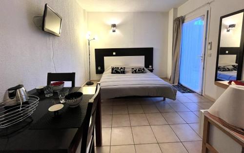 een slaapkamer met een bed en een bureau erin bij Studio avec piscine SAINT FLORENT FLOJ04 in Saint-Florent