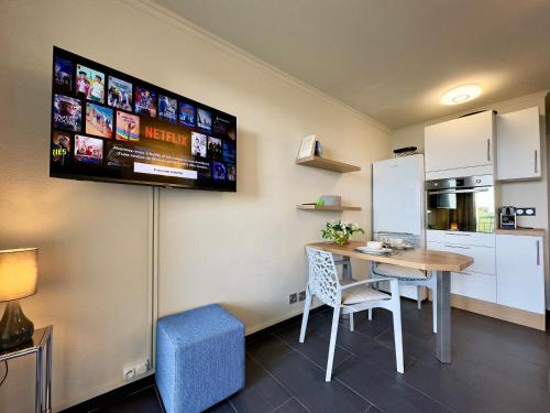 Cette chambre dispose d'une table et d'une télévision murale. dans l'établissement Le Chagall 2 SCLS Locations, à Cannes