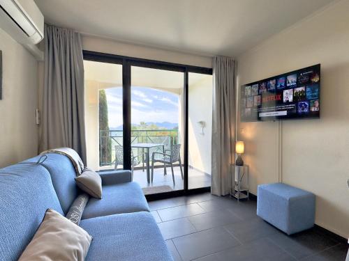 un salon avec un canapé bleu et un balcon dans l'établissement Le Chagall 2 SCLS Locations, à Cannes