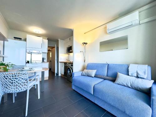 un salon avec un canapé bleu et une cuisine dans l'établissement Le Chagall 2 SCLS Locations, à Cannes