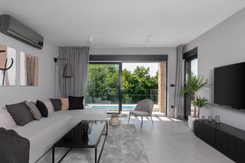 NedeščinaにあるVilla AntheaPaola near Labin - Rabac for 8 people with heated private pool and children playgroundの白いソファとテレビのあるリビングルーム