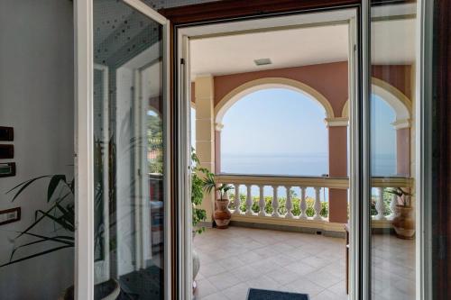 an open door to a balcony with a view of the ocean at Villa Caroleo in Ospedaletti