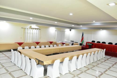 a conference room with a long table and white chairs at Quality Hotel Juba in Juba
