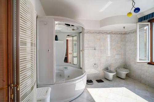 a white bathroom with a shower and a toilet at Villa Caroleo in Ospedaletti