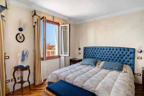 a bedroom with a blue bed and a window at Villa Caroleo in Ospedaletti