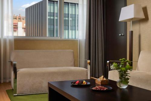 a living room with a chair and a table at NH Madrid Ribera del Manzanares in Madrid