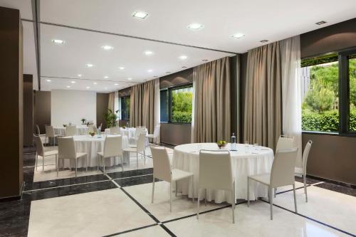 a dining room with white tables and white chairs at NH Madrid Ribera del Manzanares in Madrid