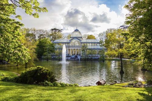 a large building with a fountain in the middle of a lake at NH Madrid Ribera del Manzanares in Madrid