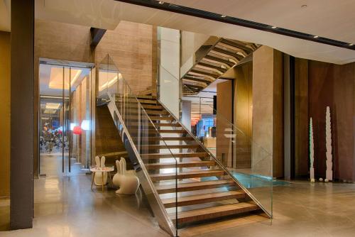 a spiral staircase in a building with a lobby at Nhow Milan in Milan