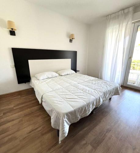 une chambre avec un grand lit avec une tête de lit noire dans l'établissement Studio avec piscine SAINT FLORENT - FLO300-134, à Saint-Florent