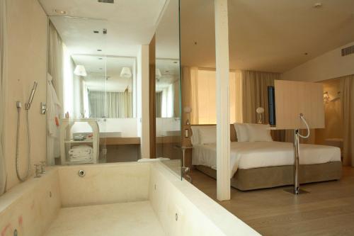 a bedroom with a bed and a tub in a room at Nhow Milan in Milan