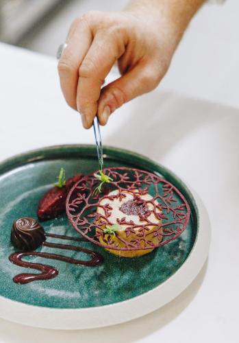 a person is eating a dessert on a plate at Hotel Corsica & Spa Serena in Calvi