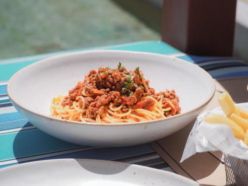 a bowl of spaghetti with meat and vegetables on a table at Pullman Phuket Panwa Beach Resort in Panwa Beach