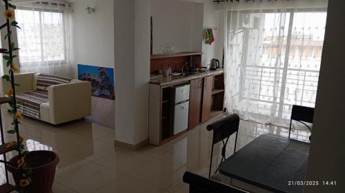 a kitchen and living room with a couch and a table at résidence le 5eme Ciel in Douala