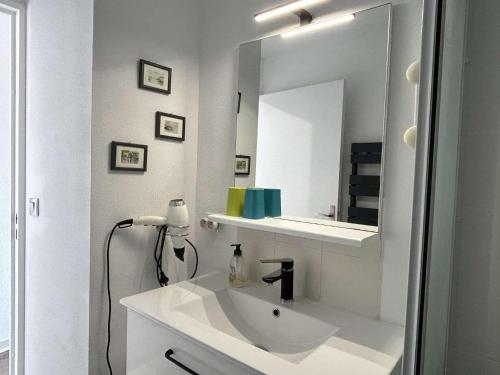 une salle de bain blanche avec un lavabo et un miroir dans l'établissement Appart 2 pièces 4 couchages BANYULS SUR MER BN090-F23, à Banyuls-sur-Mer