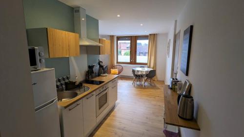 une cuisine avec un évier et une cuisinière four supérieur dans l'établissement Gite Le Muguet, à Soultz-Haut-Rhin