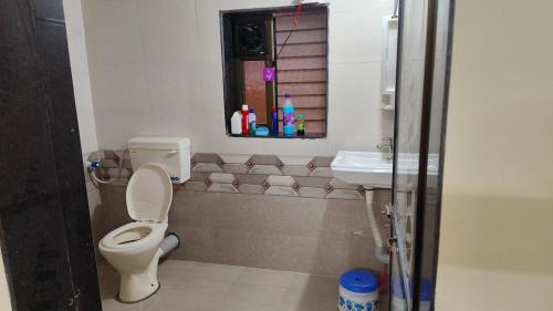 a bathroom with a toilet and a sink at Rukhmini Niwas in Pural