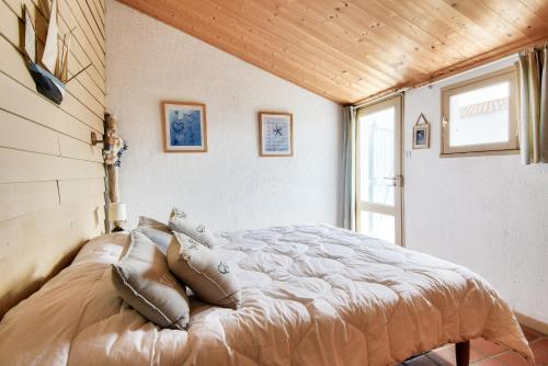 une chambre avec un lit avec des oreillers dessus dans l'établissement Maison pour 8 - 100 m de la plage - Jardin, à La Guérinière