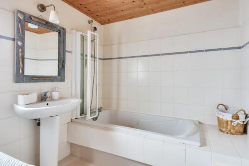 une salle de bain avec une baignoire blanche, un lavabo et un miroir dans l'établissement Maison pour 8 - 100 m de la plage - Jardin, à La Guérinière