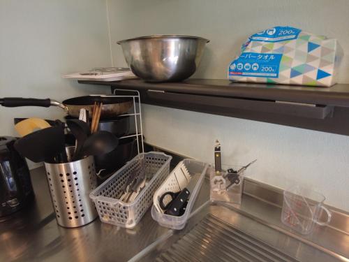 a kitchen counter with dishes and utensils on a shelf at Magic hour nasu Tochigi BBQ available in Nasu-yumoto
