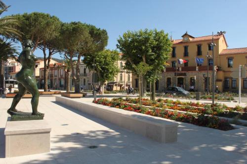 une statue dans un parc avec des fleurs et des bâtiments dans l'établissement Appart 3 pièces 6 couchages BANYULS SUR MER BN100-003C, à Banyuls-sur-Mer