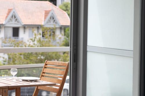 une table et une chaise en bois devant une fenêtre dans l'établissement Studio Les Pieds dans l'Eau - Welkeys, à Arcachon