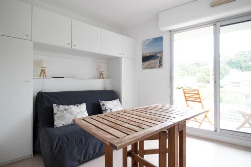 un salon avec une table et un canapé dans l'établissement Studio Les Pieds dans l'Eau - Welkeys, à Arcachon