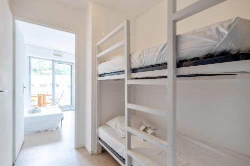 une chambre avec deux lits superposés et un miroir dans l'établissement Studio Les Pieds dans l'Eau - Welkeys, à Arcachon