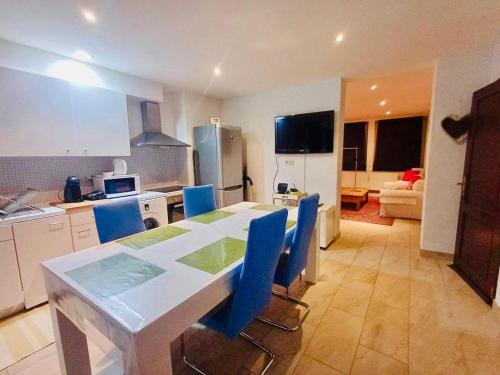 a kitchen with a table and blue chairs in a room at Plein centre de Visé in Visé