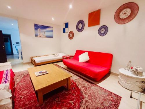 a living room with a red couch and clocks on the wall at Plein centre de Visé in Visé