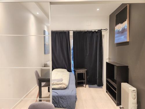 Una pequeña habitación con una cama pequeña y un televisor. en P1-Central-Cosy flat Suit All Globetrotters-2rooms, en Oslo