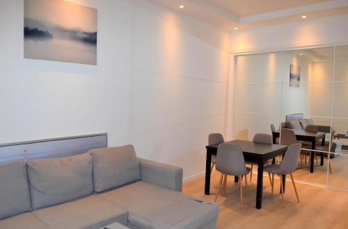 una sala de estar con un sofá, una mesa y sillas en P1-Central-Cosy flat Suit All Globetrotters-2rooms, en Oslo