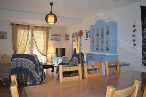 - un salon avec une table, des chaises et une armoire bleue dans l'établissement Maison 3 pièces 5 couchages BANYULS SUR MER BN000-08A, à Banyuls-sur-Mer