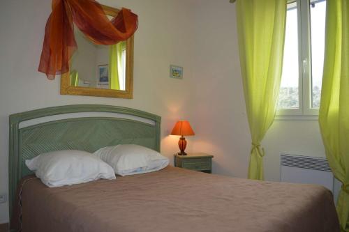 une chambre avec un lit avec un miroir et une fenêtre dans l'établissement Maison 3 pièces 5 couchages BANYULS SUR MER BN000-08A, à Banyuls-sur-Mer