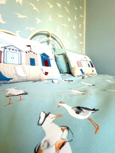 a bedroom with birds on a bed with birds on it at Carol's Chalet in Bridlington