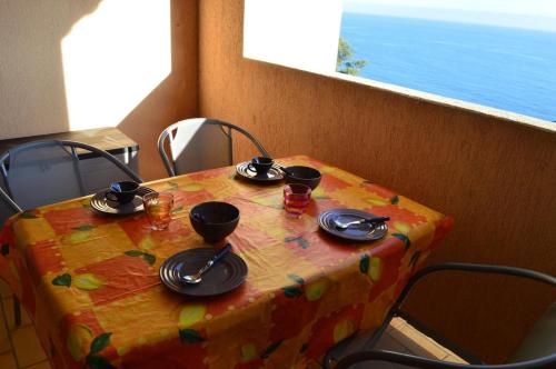 une table avec des chaises, des assiettes et des bols dans l'établissement Appart Studio cabine 4 couchages BANYULS SUR MER BN120-4202, à Banyuls-sur-Mer