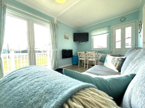 een woonkamer met een bank en een tafel met een televisie bij Carol's Chalet in Bridlington