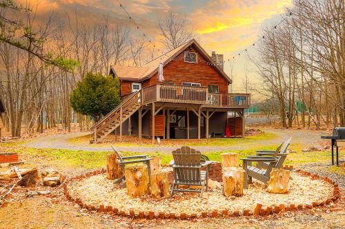 a log cabin with a table and chairs in front of it at Kids under 4 free, Jacuzzi, Sauna, Pool, Lake, Gym in Albrightsville