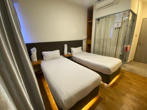 a room with two beds in a hospital room at Hotel Vevo Puchong Malaysia in Puchong