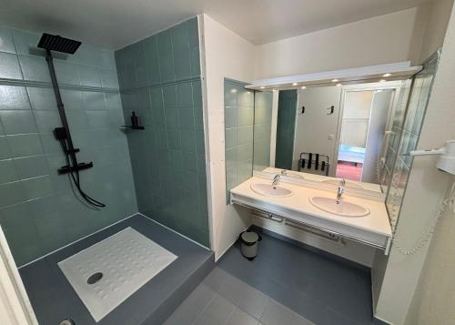 une salle de bain avec deux lavabos et une douche dans l'établissement Chambre Victory, à Colleville-sur-Mer