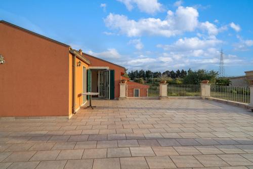 a building with a patio and a fence at Al Palmento Relais in Siracusa