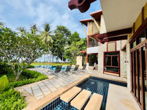 an exterior view of a villa with a swimming pool at Amatapura Beachfront Villa 12, SHA Certified in Ao Nam Mao